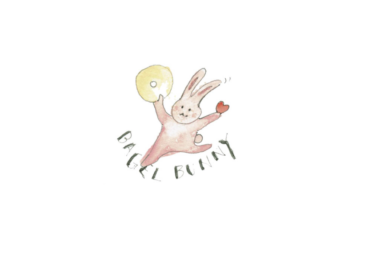 A drawing/water color of a bunny holding a bagel and heart with font saying Bagel Bunny